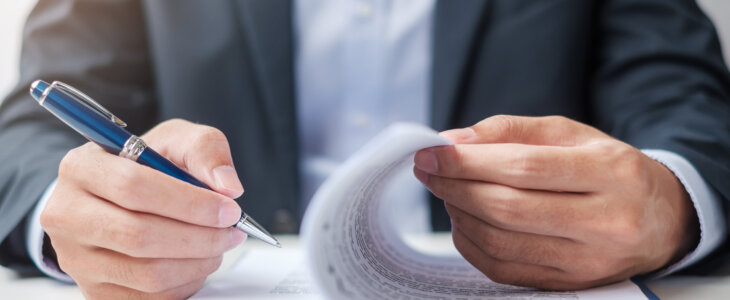 Businessman signing on contract documents after reading