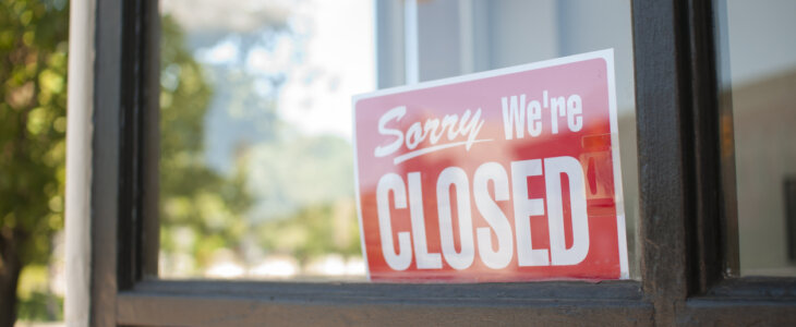 Sorry, We're Closed Sign in a storefront window