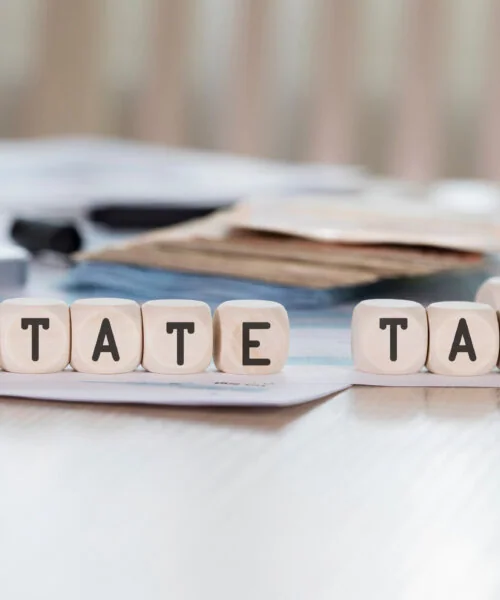 Word ESTATE TAX is composed of wooden letters.